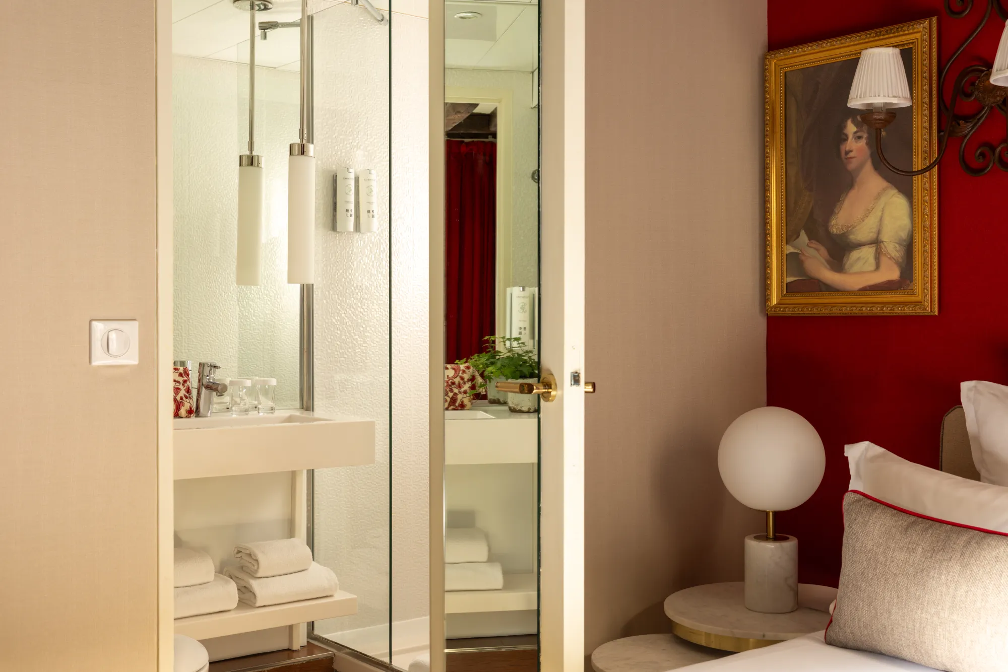 Miroir et portrait ancien encadré de fer forgé dans un angle de la chambre Classique de l'Hôtel des Deux Continents