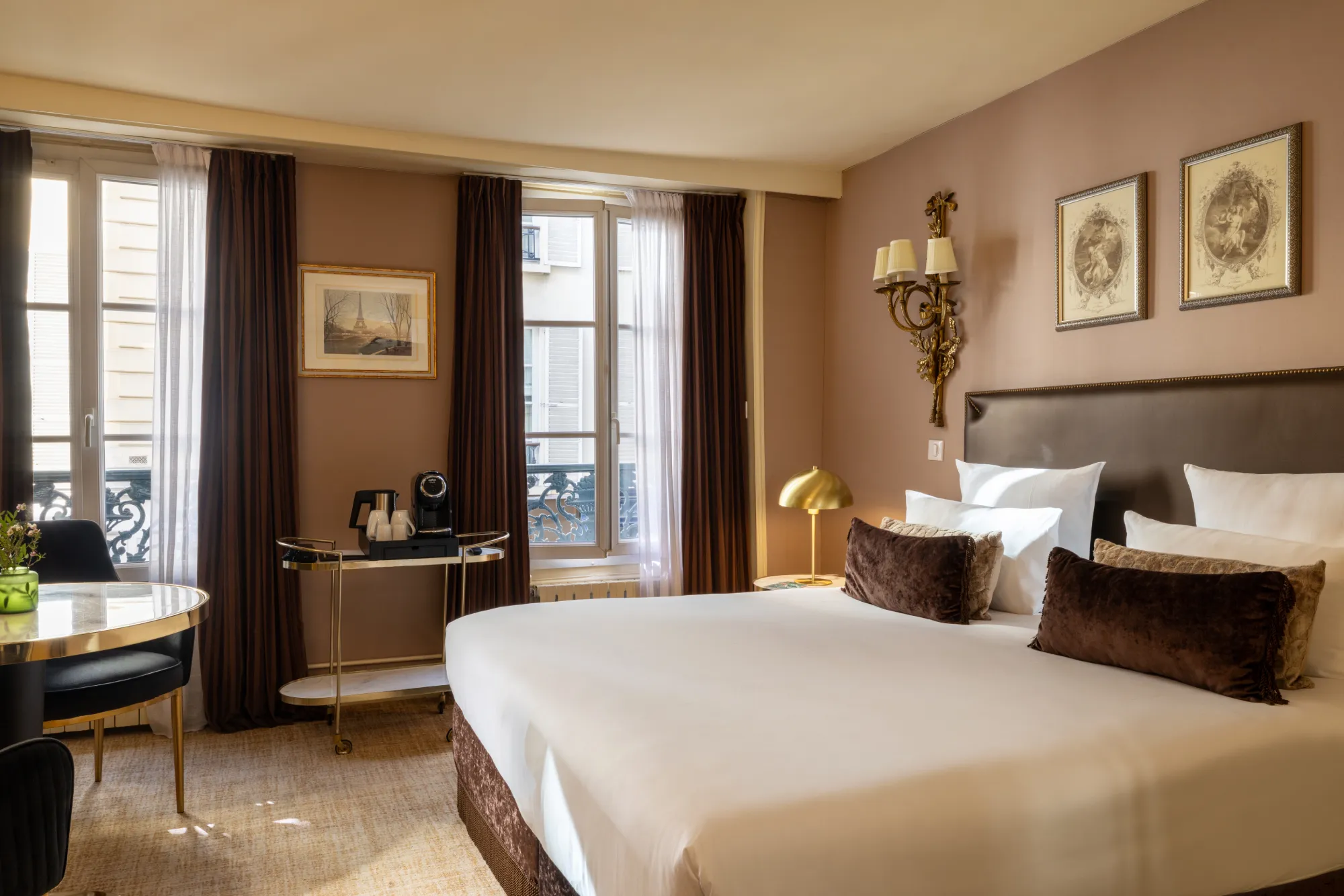 Chambre Deluxe aux murs taupe avec gravures encadrées et fenêtre sur rue parisienne