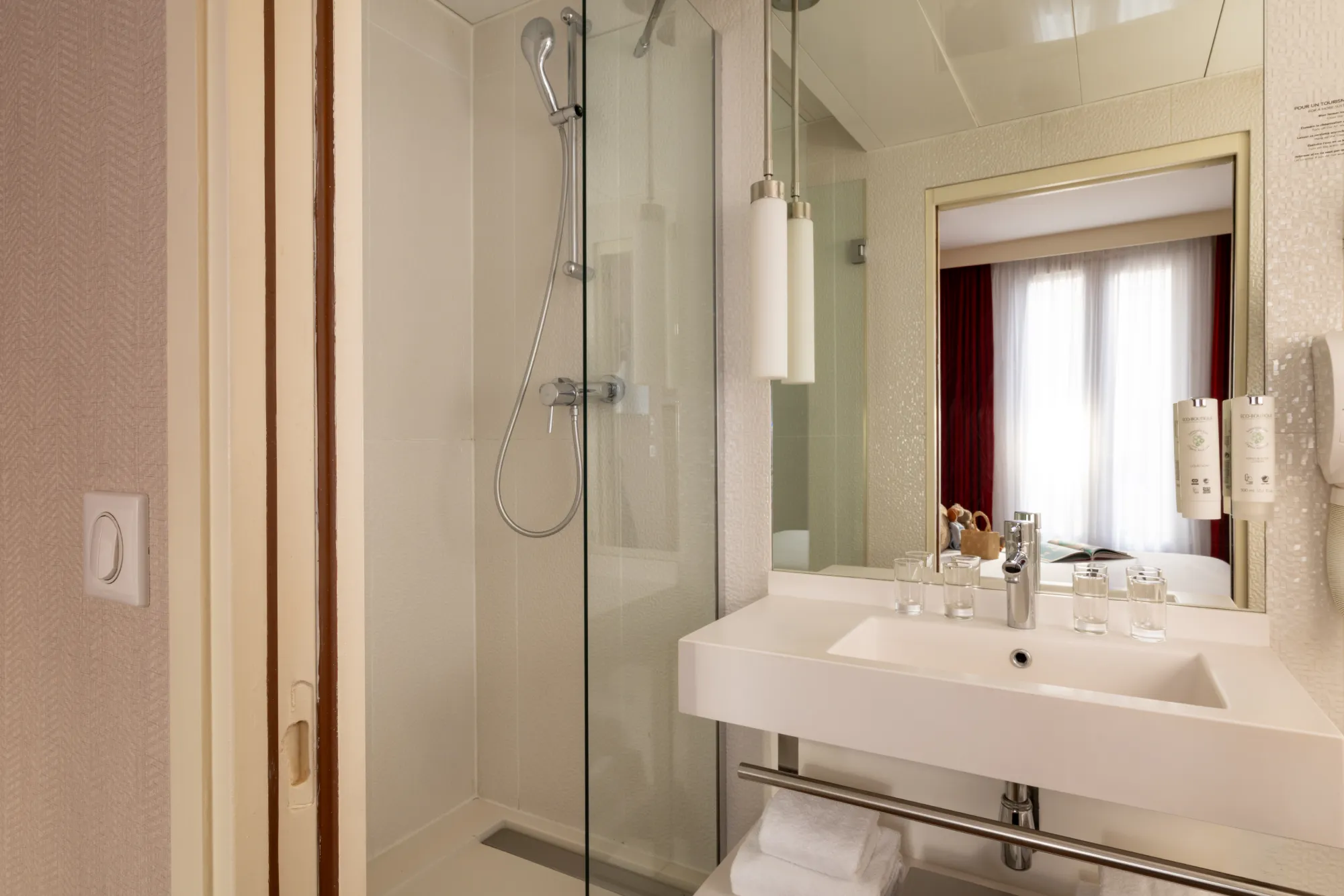 Douche à l'italienne vitrée et vasque sur pied chromé dans la salle de bain de la chambre familiale