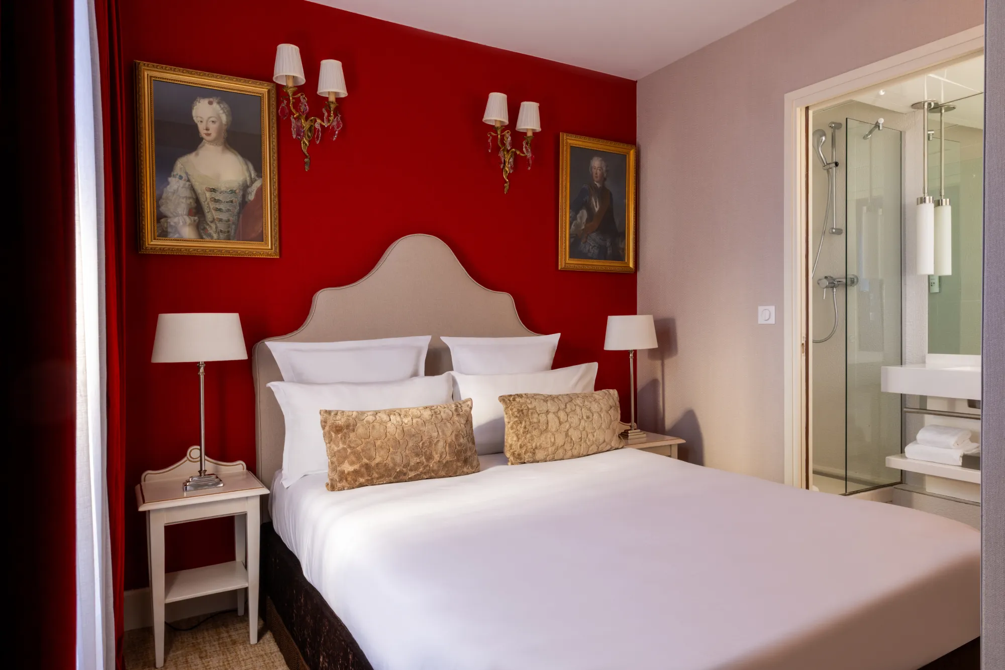 Deux portraits anciens et appliques murales encadrant le lit dans la chambre familiale à l'Hôtel des Deux Continents