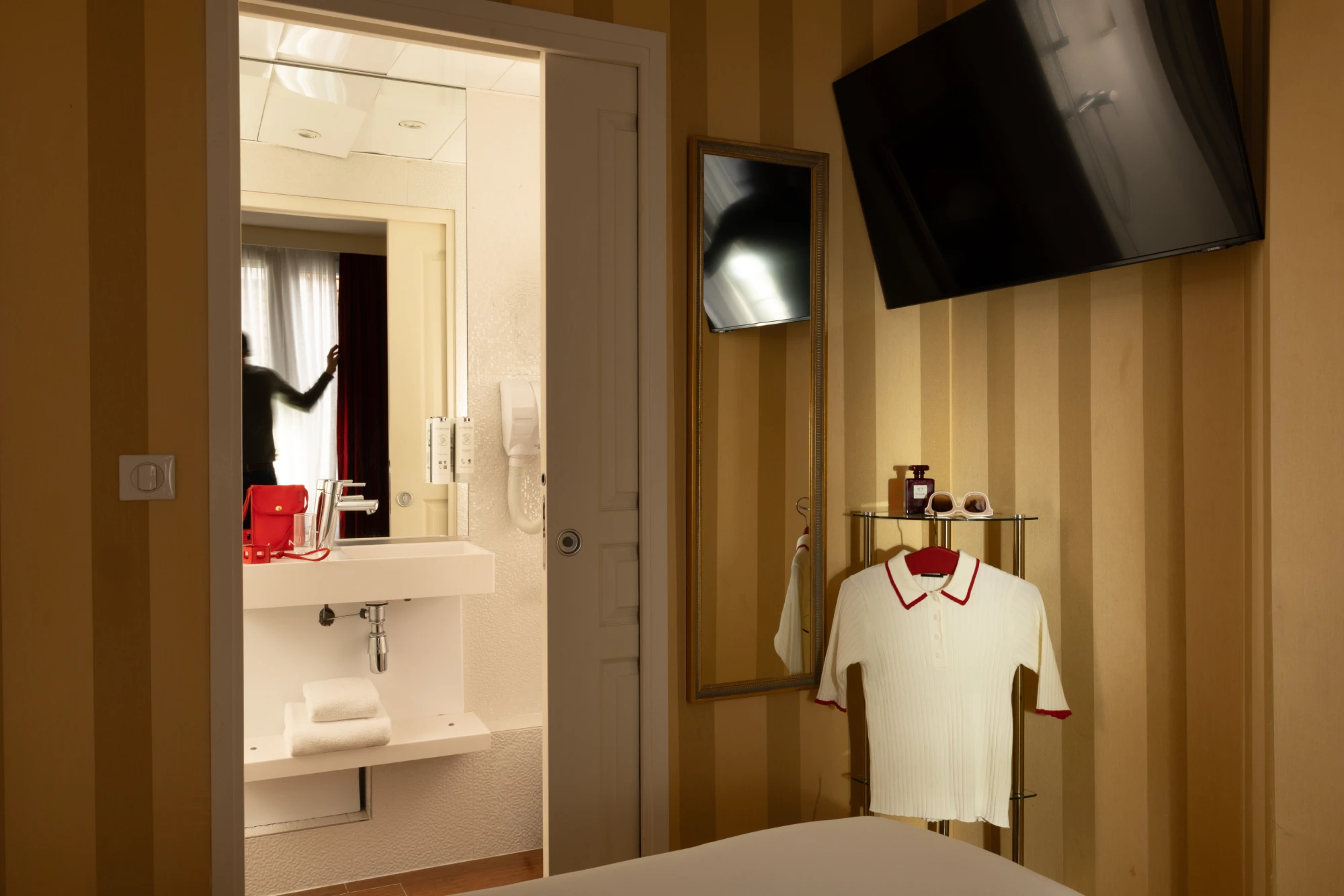 Chambre single avec télévision murale et vue sur la salle de bain à l'Hôtel des Deux Continents