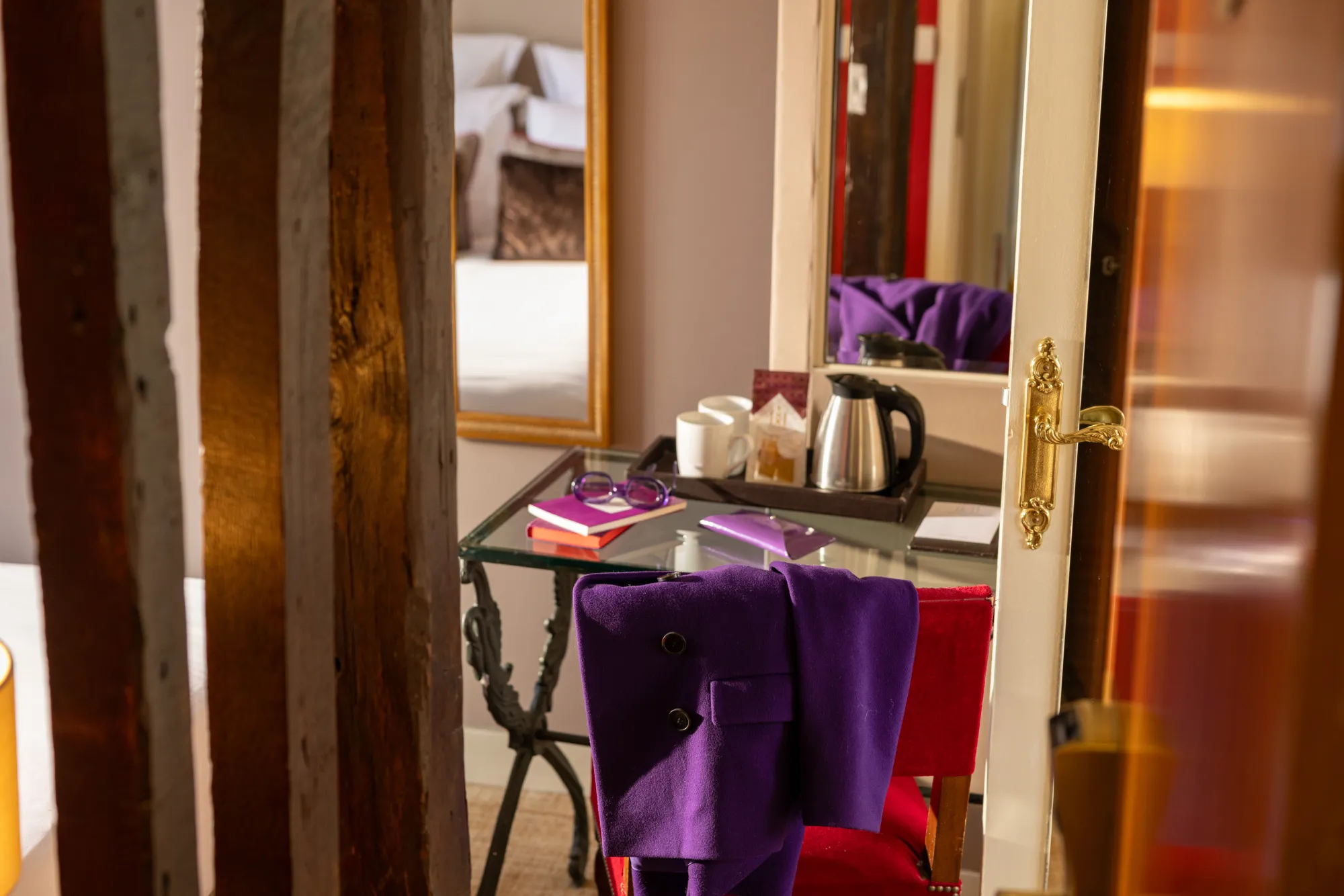 Plateau avec bouilloire et tasses posé sur une console, entre poutres apparentes et tissu violet, Chambre Terrasse