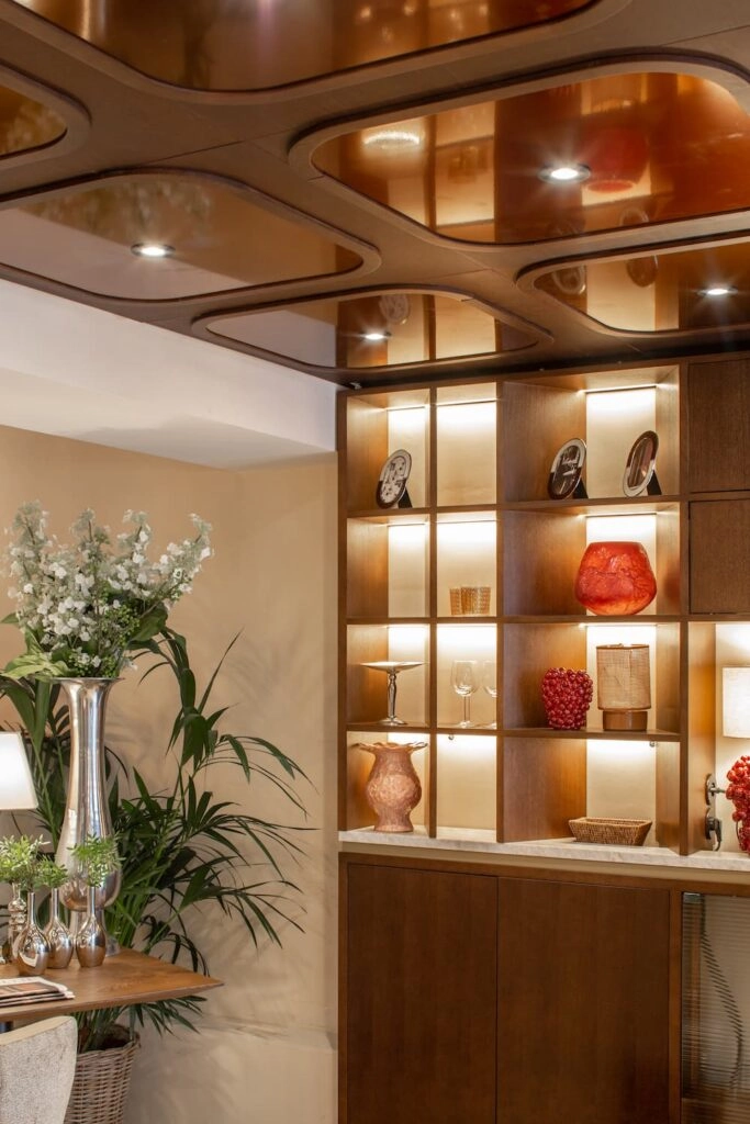 Étagère décorative et plafond cuivré dans l'espace bar de l'Hôtel des Deux Continents