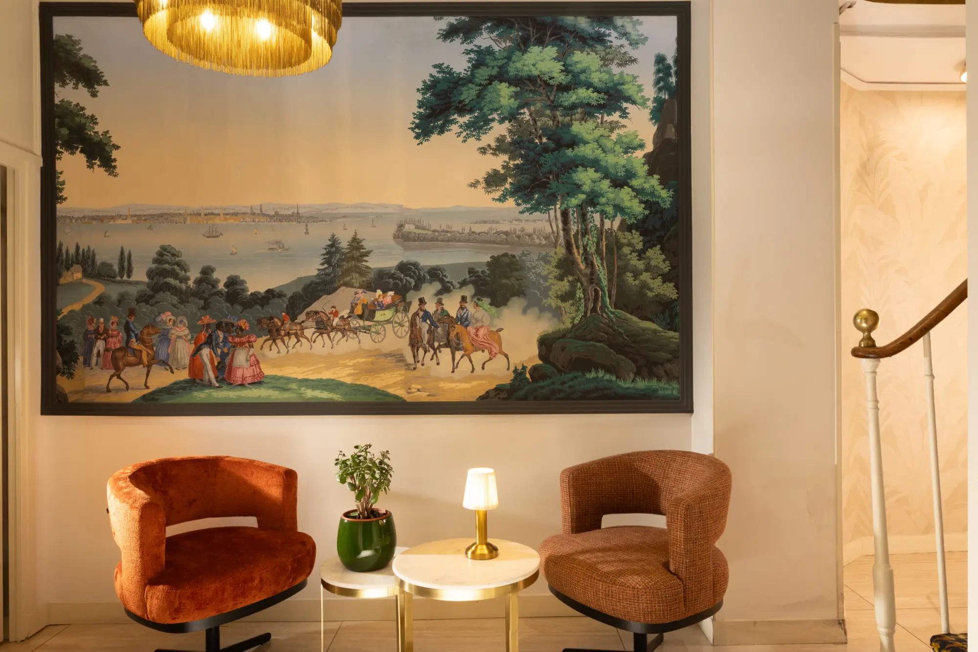 Salon cosy avec tapisserie murale et fauteuils en velours terracotta à l'Hôtel des Deux Continents